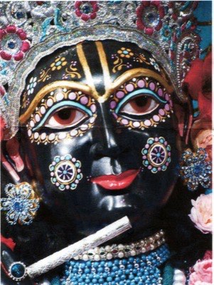 Close-up of a dark-skinned Krishna idol holding a flute