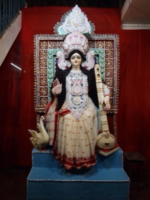 Saraswati idol in white sari with veena and swan
