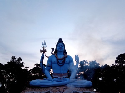 Blue Shiva statue meditating with trident and cobra