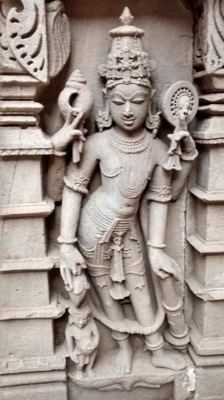 Carved Vishnu with four arms holding a conch and disc